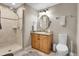 Well-lit bathroom featuring a walk-in shower, wood vanity, and neutral tones at 7818 S Zeno St, Centennial, CO 80016