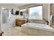 Luxurious bathroom with soaking tub, travertine tile, and double vanities at 7818 S Zeno St, Centennial, CO 80016