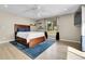 Bright bedroom featuring a wooden bed frame, ceiling fan and a large window overlooking the yard at 7818 S Zeno St, Centennial, CO 80016