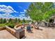 Outdoor fire pit area with Adirondack chairs, stone accents, lush landscaping, and blue skies overhead at 7818 S Zeno St, Centennial, CO 80016