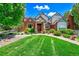 Charming home exterior with well-manicured lawn, stone accents, lush landscaping, and an inviting front entrance at 7818 S Zeno St, Centennial, CO 80016