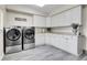 Laundry room with white cabinets, countertops, and stainless steel washer and dryer at 7818 S Zeno St, Centennial, CO 80016