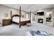 Main bedroom featuring a fireplace, a four-poster bed, and a doorway into the closet at 7818 S Zeno St, Centennial, CO 80016