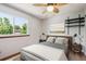 Inviting bedroom with ceiling fan, stylish decor, and a view of lush greenery at 984 Shadow Mountain Dr, Highlands Ranch, CO 80126