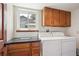 Bright laundry room equipped with a washer, dryer, counter space, and overhead cabinets at 984 Shadow Mountain Dr, Highlands Ranch, CO 80126