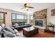 Cozy living room with stone fireplace, hardwood floors, and large windows showcasing the scenic view at 984 Shadow Mountain Dr, Highlands Ranch, CO 80126