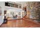 Bright living room boasts wood floors, a stone accent wall, and stairs leading to a second-floor loft at 984 Shadow Mountain Dr, Highlands Ranch, CO 80126