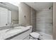 A clean bathroom featuring a shower over tub, granite countertop, and grey wood-look tile at 1777 S Pitkin St # A, Aurora, CO 80017