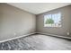 An empty bedroom with a large window and grey wood-look floors at 1777 S Pitkin St # A, Aurora, CO 80017