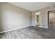 An empty bedroom with a open door to bathroom and grey wood-look floors at 1777 S Pitkin St # A, Aurora, CO 80017