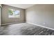 An empty bedroom with a large window and grey wood-look floors at 1777 S Pitkin St # A, Aurora, CO 80017