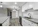 Kitchen and dining area with stainless steel dishwasher, granite counters and new wood-look flooring at 1777 S Pitkin St # A, Aurora, CO 80017