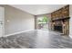 Comfortable living room featuring a stone fireplace, wood-look floors, and access to a balcony at 1777 S Pitkin St # A, Aurora, CO 80017