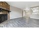 Spacious living room with stone fireplace flowing into an open floor plan with wood-look floors at 1777 S Pitkin St # A, Aurora, CO 80017