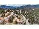 Aerial view of a property surrounded by dense trees and winding roads with mountain views at 248 Copperdale Ln, Golden, CO 80403