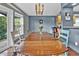 Cozy dining room with modern lighting, large wooden table, and blue accent wall looking to kitchen at 248 Copperdale Ln, Golden, CO 80403