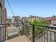 Spacious wood balcony overlooking mature trees and an urban neighborhood with apartments and parking garages at 2501 15Th St # 3D, Denver, CO 80211
