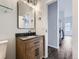 Bathroom featuring a wooden vanity with a dark countertop, modern fixtures, and a large mirror at 2501 15Th St # 3D, Denver, CO 80211