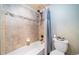 Clean bathroom with tub and shower, tile surround, and toilet at 6829 Juniper Ct, Frederick, CO 80530