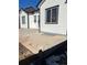 Home exterior features white siding, black trim, modern windows, with a concrete patio, foundation, and partially snow-covered yard at 6829 Juniper Ct, Frederick, CO 80530