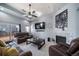 Living room with fireplace, leather furniture, and large TV at 6829 Juniper Ct, Frederick, CO 80530