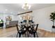 Chic dining area with a glass-topped table, modern chairs, and a view into the living room and kitchen at 1815 Ingalls St, Lakewood, CO 80214