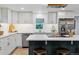 Updated kitchen featuring white cabinets, stainless steel appliances, and a breakfast bar at 1815 Ingalls St, Lakewood, CO 80214