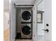 Modern laundry area with stacked washer and dryer units and stylish black hexagon tile flooring at 1815 Ingalls St, Lakewood, CO 80214
