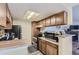 Kitchen with black appliances and wood cabinets leads to a cozy fireplace area at 18193 E Kentucky Ave # 203, Aurora, CO 80017