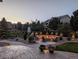 Inviting backyard with a built-in stone fire pit and custom landscaping at 7765 Yankee Ct, Arvada, CO 80007