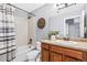 Well-lit bathroom featuring a shower/tub combo and a vanity with a large mirror and wood accents at 7765 Yankee Ct, Arvada, CO 80007