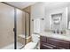 Bathroom featuring tiled shower and modern vanity with granite countertop at 7765 Yankee Ct, Arvada, CO 80007