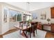 Bright dining area featuring a large window, hardwood floors, and elegant lighting fixtures at 7765 Yankee Ct, Arvada, CO 80007