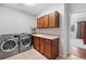 Functional laundry room with washer, dryer, sink, and cabinetry at 7765 Yankee Ct, Arvada, CO 80007