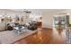 Spacious living room featuring hardwood floors, a comfortable seating area, and seamless flow to the kitchen at 7765 Yankee Ct, Arvada, CO 80007