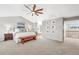 Large main bedroom featuring a ceiling fan, a seating area, and a view of an ensuite bathroom at 7765 Yankee Ct, Arvada, CO 80007
