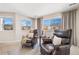 Cozy sitting area with comfortable leather chairs, windows, and a small table with a lamp at 7765 Yankee Ct, Arvada, CO 80007