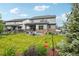 Wide backyard showing the home's exterior, stamped concrete patio, chairs, lush lawn, and plantings at 3365 S Poppy St, Morrison, CO 80465