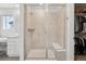 Glass enclosed shower with built-in bench in bright bathroom near walk-in closet at 3365 S Poppy St, Morrison, CO 80465