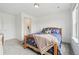 Neutral bedroom with a wood frame bed, a colorful duvet, and simple interior design at 3365 S Poppy St, Morrison, CO 80465