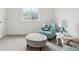 Cozy bedroom with reading nook, blue chair, tufted ottoman, and great natural light at 3365 S Poppy St, Morrison, CO 80465