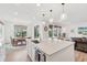 Bright kitchen with an island, white cabinets, and an open dining and living area at 3365 S Poppy St, Morrison, CO 80465
