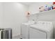 Well-lit laundry room equipped with modern, white washer and dryer units at 3365 S Poppy St, Morrison, CO 80465