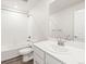 Bright bathroom with a shower over the tub, white cabinets, and a large mirror at 14422 Pansy Loop, Morrison, CO 80465