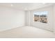 Sunlit bedroom showcases a large window with natural light and neutral carpet at 14422 Pansy Loop, Morrison, CO 80465