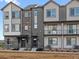 Modern townhome exteriors with gray siding, brick accents, covered entryways, and small, landscaped front yards at 14422 Pansy Loop, Morrison, CO 80465