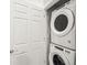 Compact laundry room with stacked white washer and dryer units, and a white door at 14422 Pansy Loop, Morrison, CO 80465