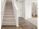 Carpeted stairs lead to a finished basement area with tile floor bathroom and white trim door at 14422 Pansy Loop, Morrison, CO 80465