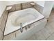 A jetted tub with tile surround, chrome fixtures and tile floors at 14822 E Adriatic Pl, Aurora, CO 80014