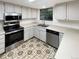 Bright kitchen features stainless appliances, white cabinets, and stylish tile flooring at 14822 E Adriatic Pl, Aurora, CO 80014